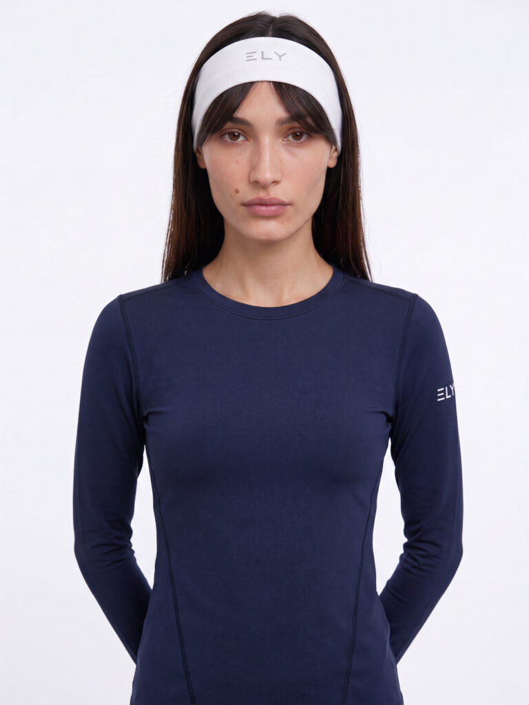Bella עם סרט ראש לבן של ELY ACTIVE וחולצת שרוול ארוך כחולה כהה