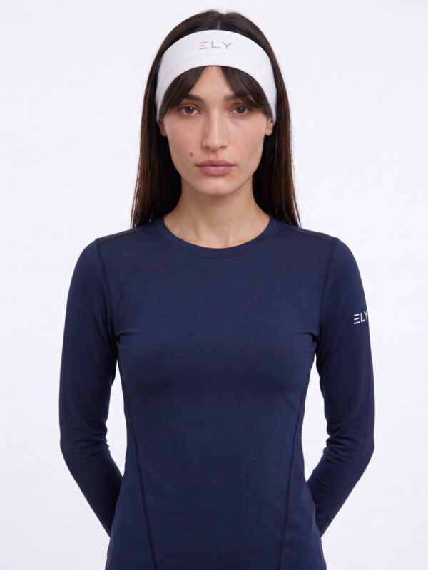 Bella עם סרט ראש לבן של ELY ACTIVE וחולצת שרוול ארוך כחולה כהה