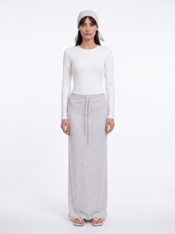 Bella wearing ESPRESSO light gray skirt and headscarf set with white Skill bodysuit and white TOTEME sandals